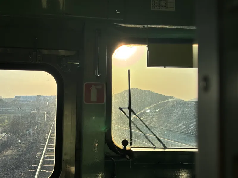 桃太郎線の車内から見た夕日。この日は卒業式を終えた高校生が多数乗車していた。
